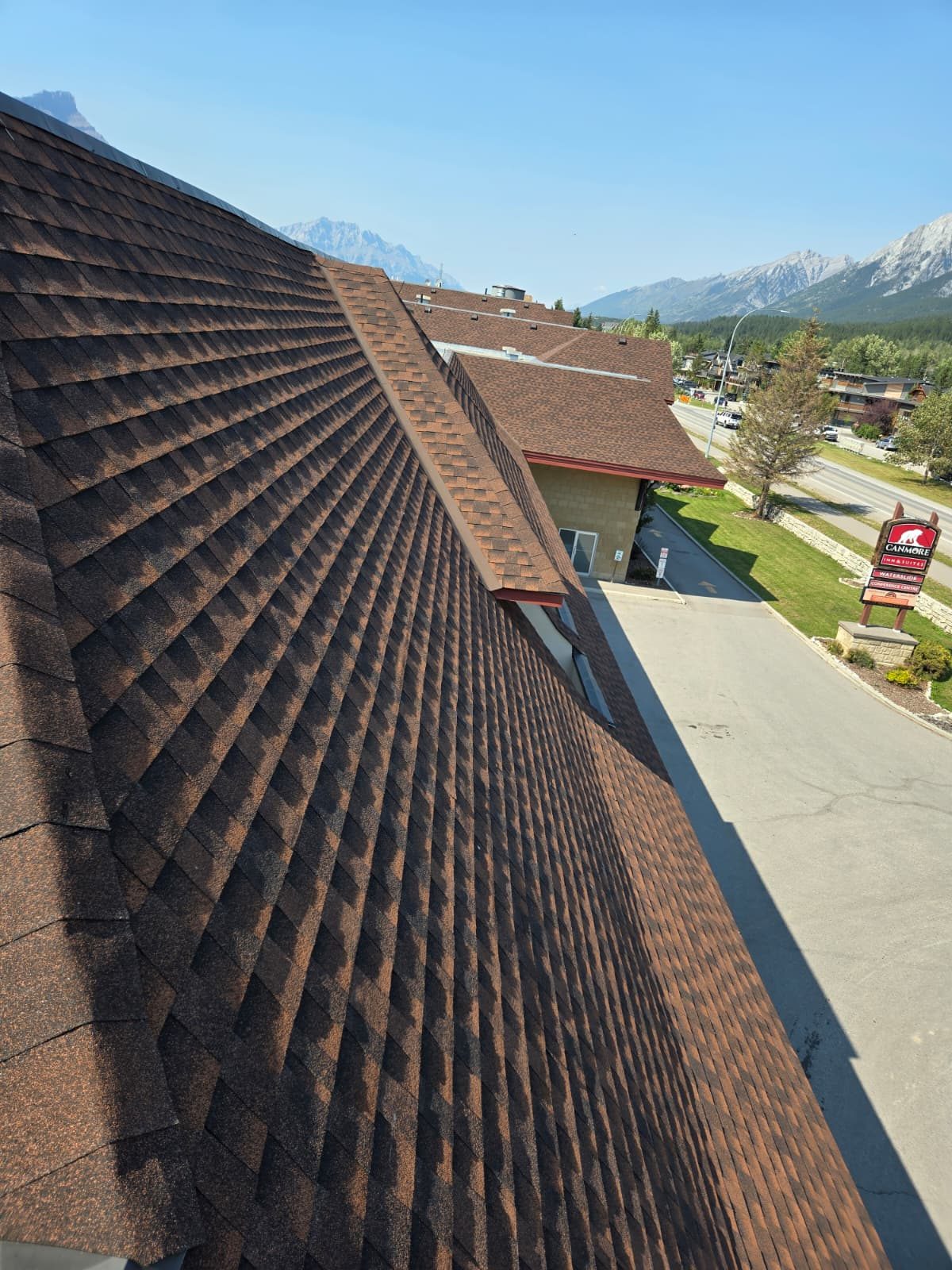 Brown asphalt shingle roof with clean lines on a large mountain-town building
