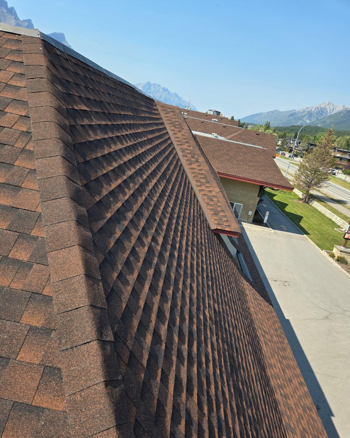 Well-kept brown asphalt shingle roof with a clean valley