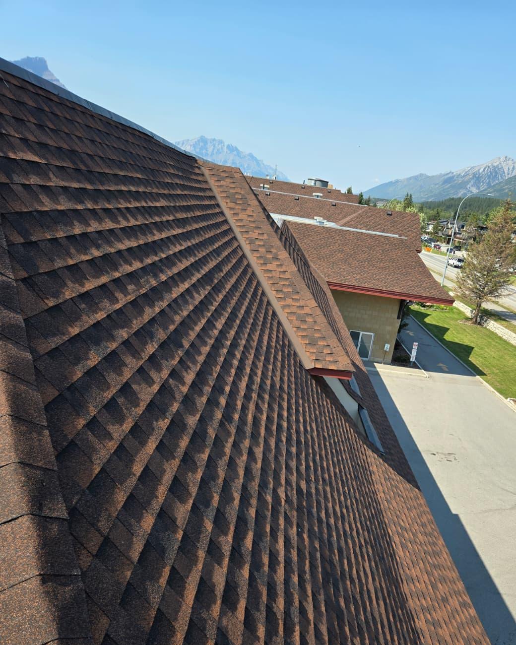 Clean brown shingle roof running down to a valley
