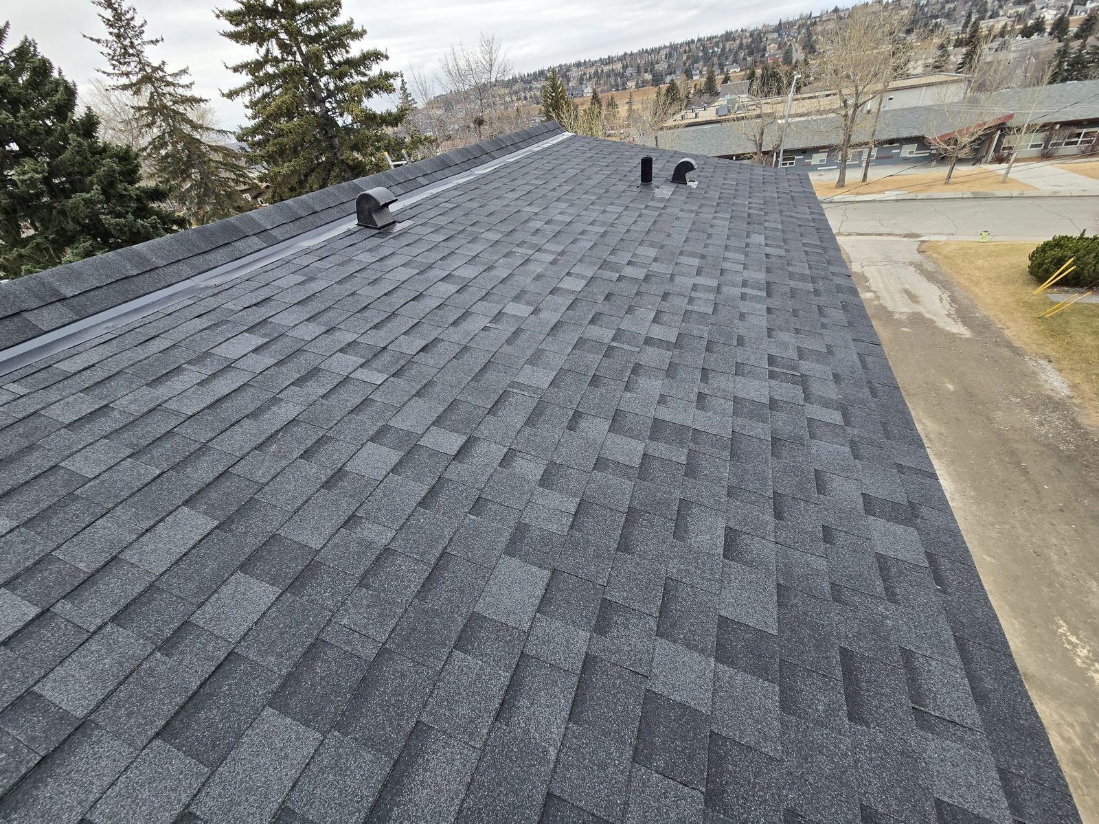 Dark grey shingle roof with ridge flashing, vents and roof edge, marked with five numbered inspection points