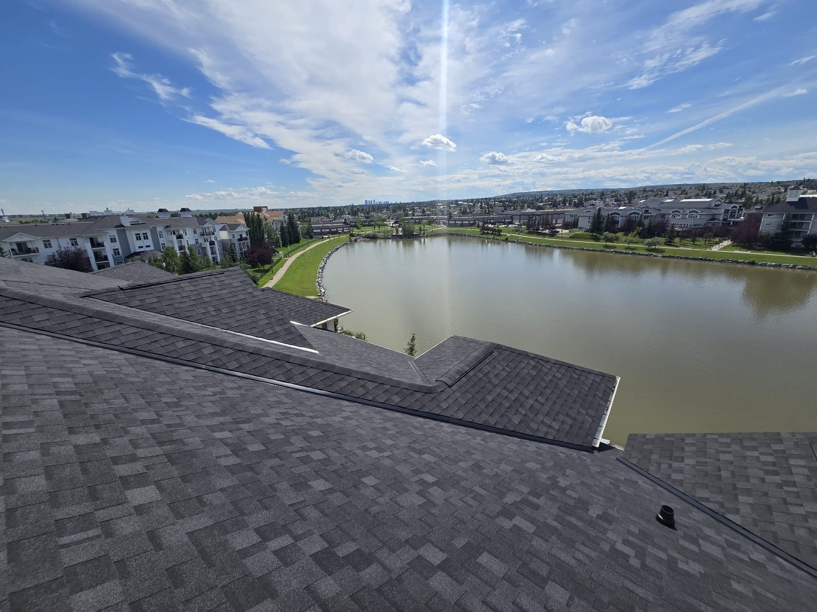 Dark shingle roofs of a lakeside residential complex