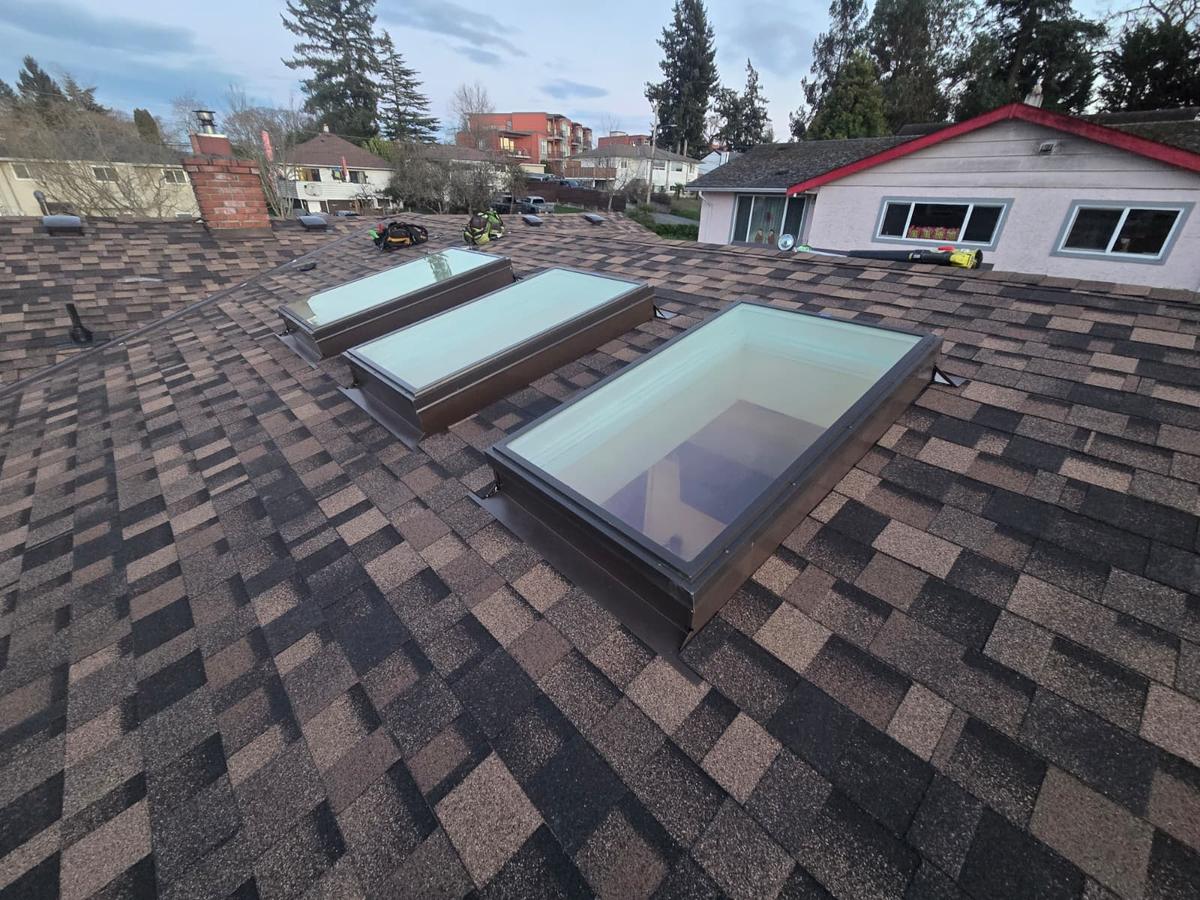 Three skylights with new flashing set into brown shingles